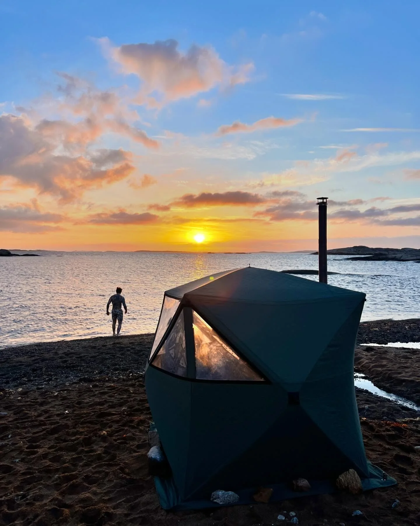 Green northern lights dancing over the snowy mountains and fjord near Tromsø